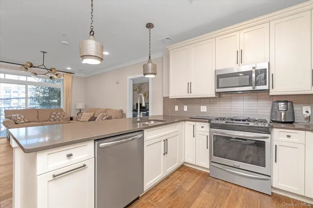 a kitchen with stainless steel appliances granite countertop a sink and cabinets with wooden floor
