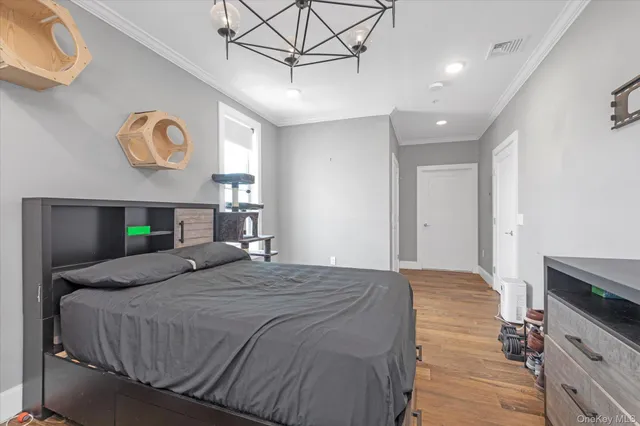 a spacious bedroom with a bed and a chandelier