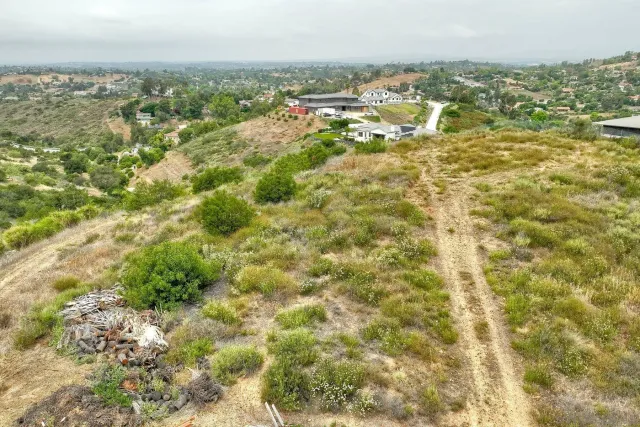 an aerial view of residential houses with outdoor space and trees