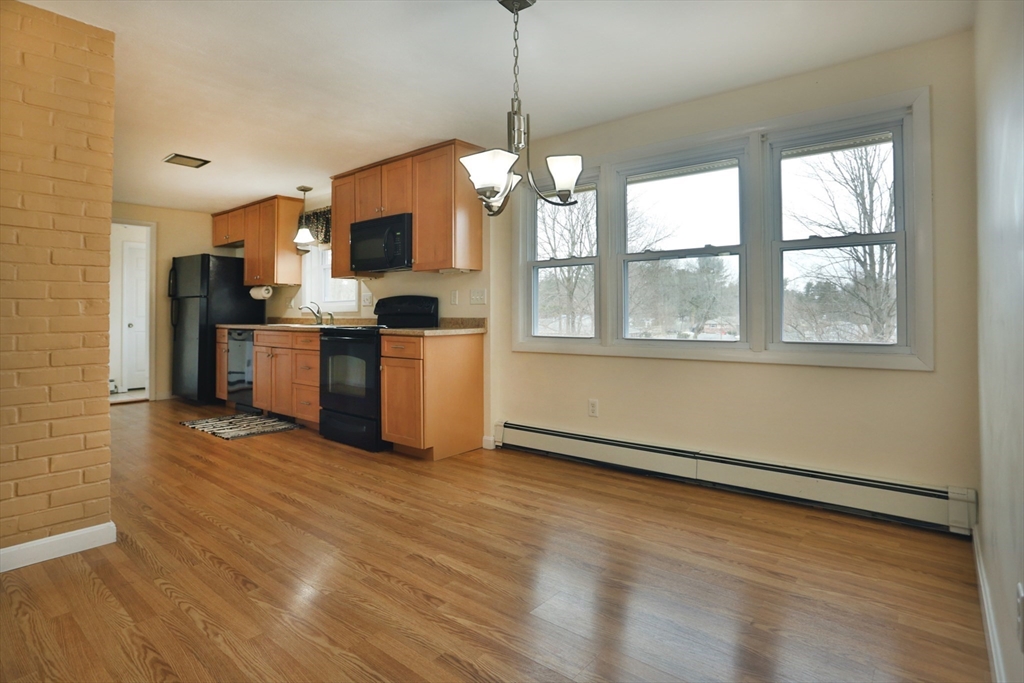 151 Turnpike Road Chelmsford, MA 01824 - Photo 11 of 21 a view of a kitchen with stainless steel appliances granite countertop a stove top oven a sink dishwasher a refrigerator and a dining table with wooden floor