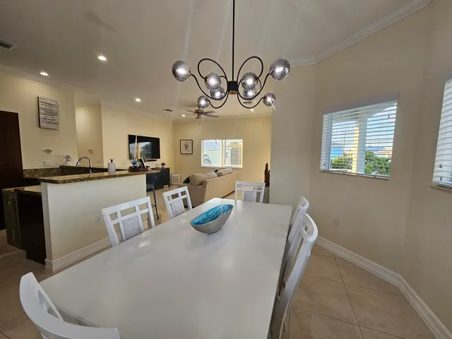 a kitchen with stainless steel appliances a table chairs and microwave