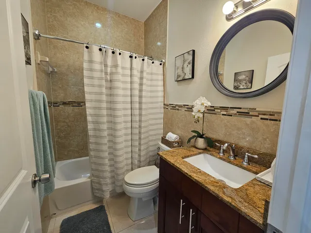 a bathroom with a granite countertop sink toilet and shower