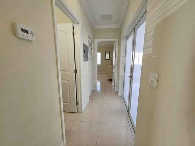 a view of a hallway with wooden floor and a bathroom