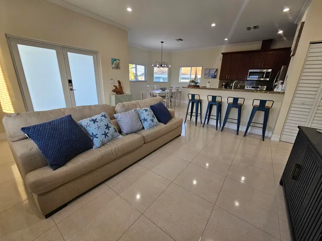 a living room with stainless steel appliances furniture and a kitchen view