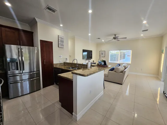 a kitchen with stainless steel appliances granite countertop a refrigerator and a sink