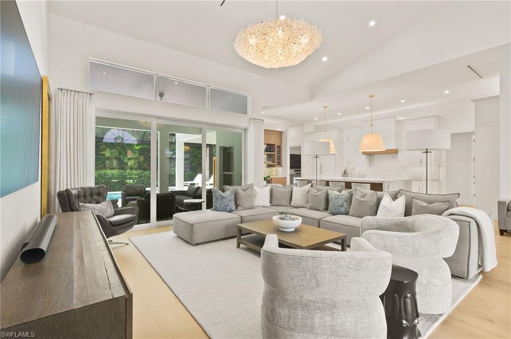 a living room with furniture kitchen and a large window