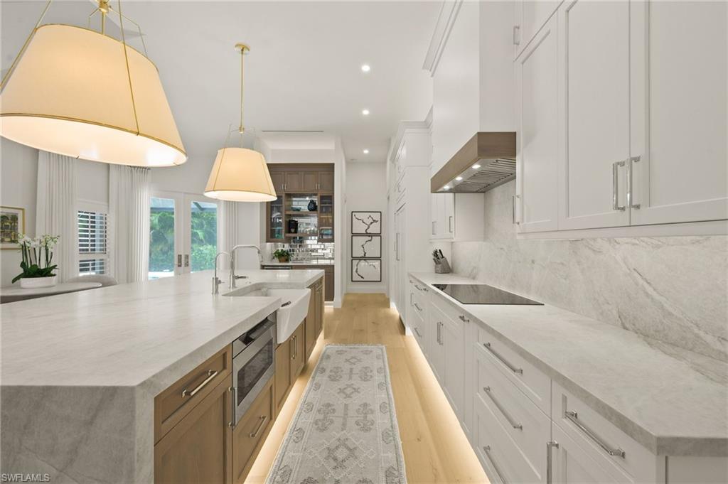 6689 Mill Run Road Naples, FL 34109 - Photo 12 of 37 a large kitchen with kitchen island a large counter space a sink a window and stainless steel appliances