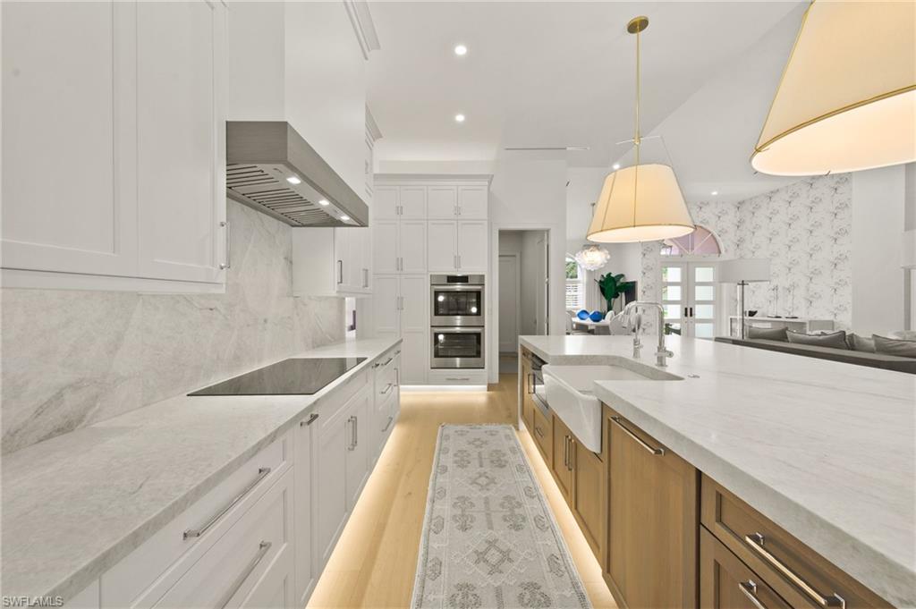 6689 Mill Run Road Naples, FL 34109 - Photo 14 of 37 a large kitchen with kitchen island a large counter space a sink and appliances