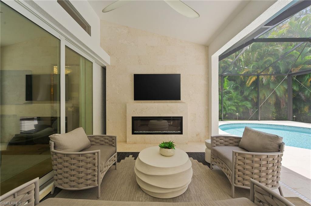 6689 Mill Run Road Naples, FL 34109 - Photo 16 of 37 a living room with furniture a flat screen tv and a fireplace