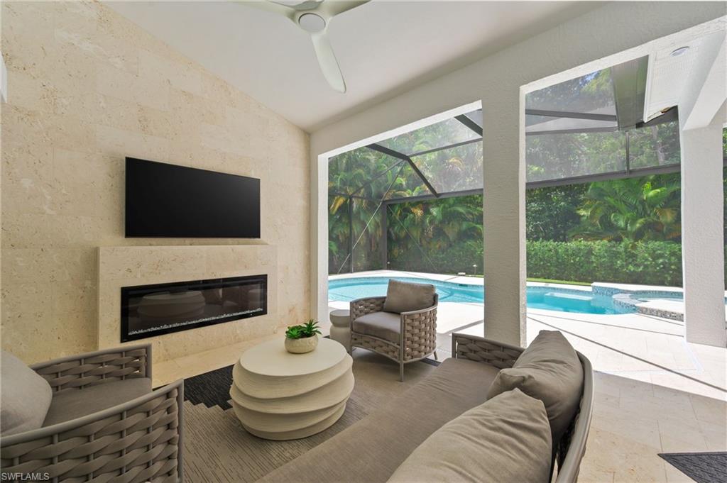 6689 Mill Run Road Naples, FL 34109 - Photo 17 of 37 a living room with furniture a fireplace and a large window
