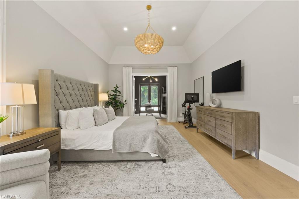 6689 Mill Run Road Naples, FL 34109 - Photo 19 of 37 a spacious bedroom with a bed and a flat screen tv