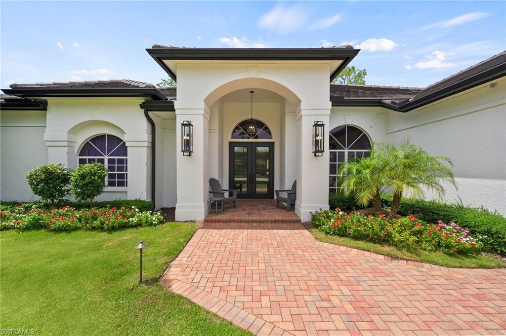 6689 Mill Run Road Naples, FL 34109 - Photo 2 of 37 a front view of a house with a garden