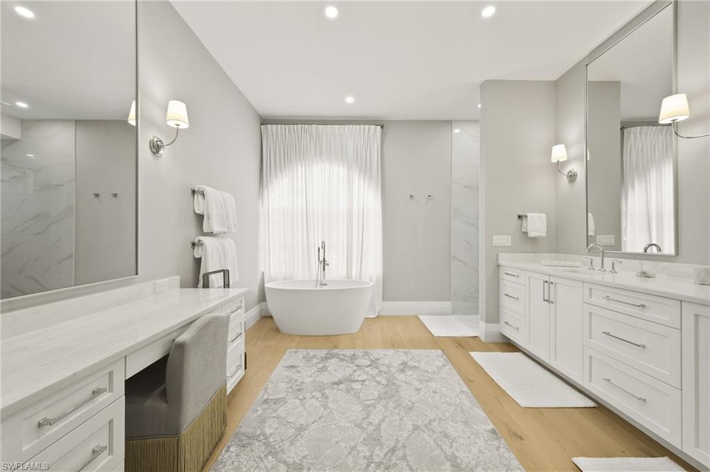 6689 Mill Run Road Naples, FL 34109 - Photo 22 of 37 a spacious bathroom with a granite countertop sink a toilet a large mirror and shower