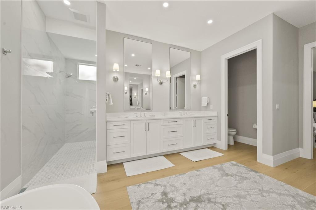6689 Mill Run Road Naples, FL 34109 - Photo 23 of 37 a bathroom with a sink a toilet and shower