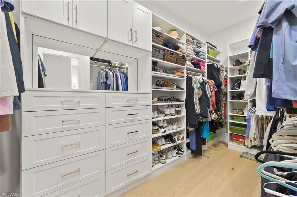 6689 Mill Run Road Naples, FL 34109 - Photo 24 of 37 a view of walk in closet with clothes and shoes