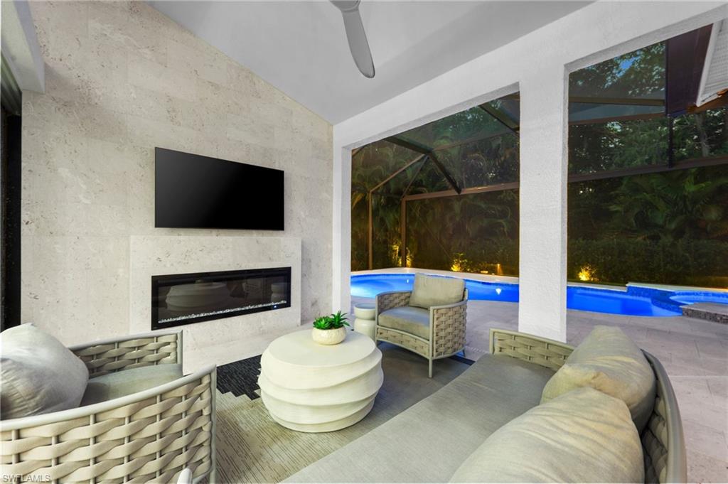 6689 Mill Run Road Naples, FL 34109 - Photo 29 of 37 a living room with furniture a flat screen tv and a fireplace