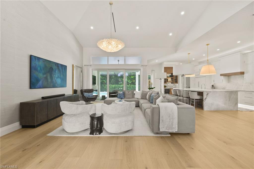 6689 Mill Run Road Naples, FL 34109 - Photo 3 of 37 a living room with couches and kitchen view with wooden floor
