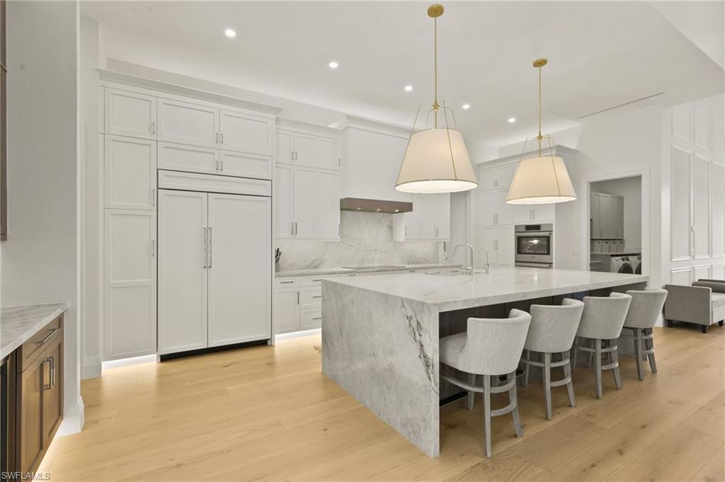 6689 Mill Run Road Naples, FL 34109 - Photo 6 of 37 a kitchen with kitchen island granite countertop a table and a chandelier