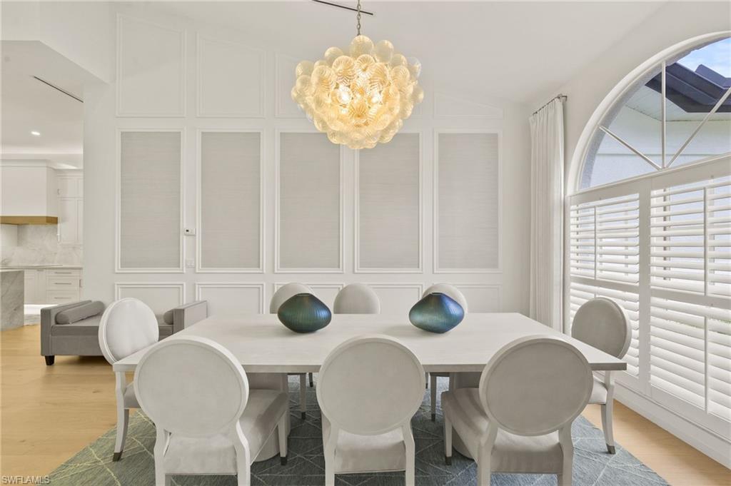 6689 Mill Run Road Naples, FL 34109 - Photo 10 of 37 a view of a dining room with furniture and chandelier