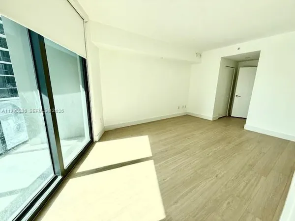 an empty room with wooden floor and door