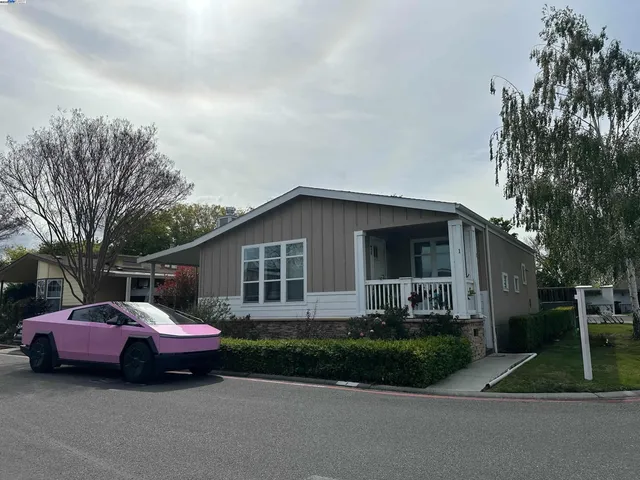 a front view of a house with a garden and trees