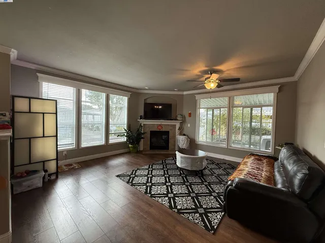 a living room with furniture large window and wooden floor