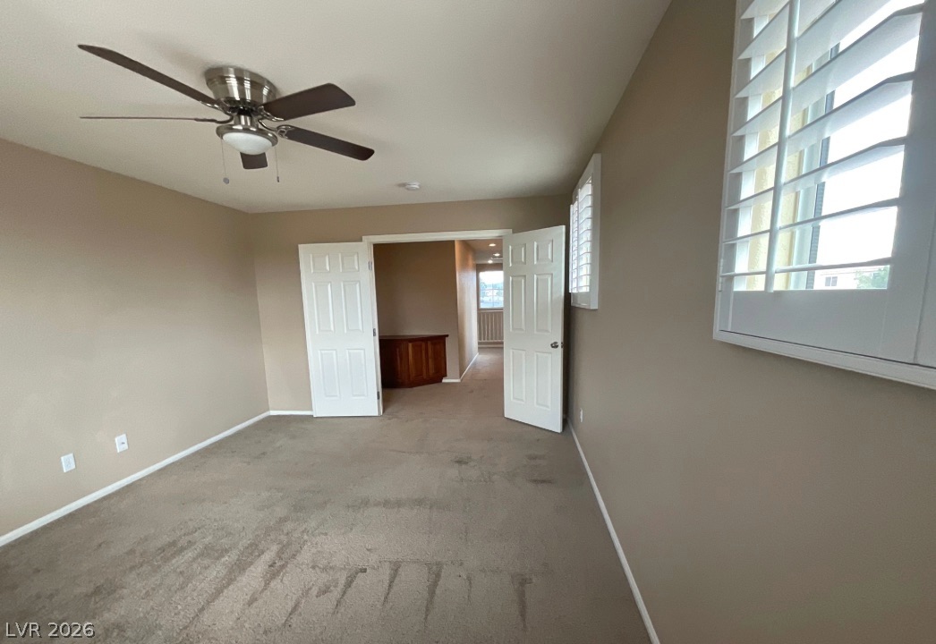10841 Paradise Road Henderson, NV 89052 - Photo 20 of 35 A versatile room featuring a ceiling fan, plush carpeting, and elegant plantation shutters.