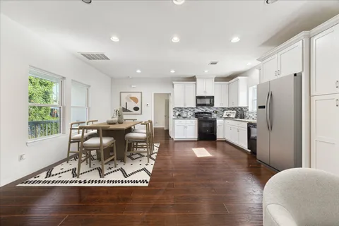 a kitchen with a table chairs refrigerator and cabinets