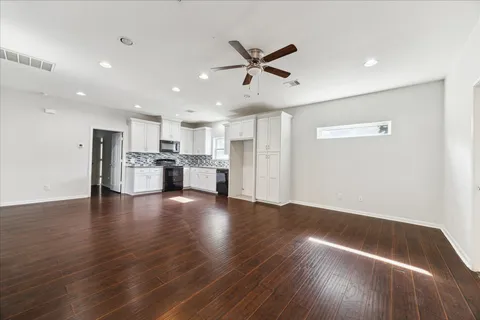 a view of empty room with wooden floor and window