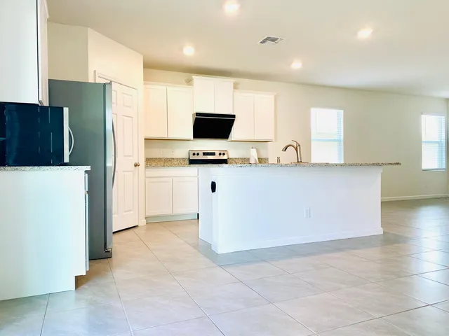 a kitchen with stainless steel appliances a refrigerator and a stove top oven