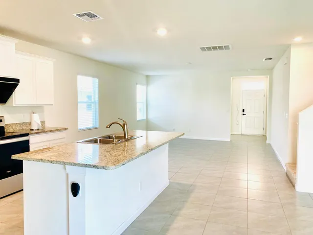 a large kitchen with granite countertop a sink and a stove