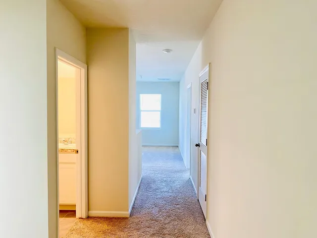 a view of a hallway with wooden floor