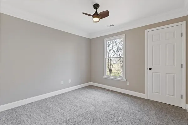 an empty room with windows and fan