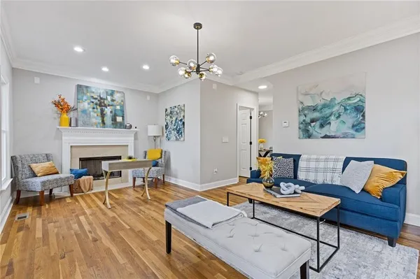 a living room with furniture a fireplace and a chandelier