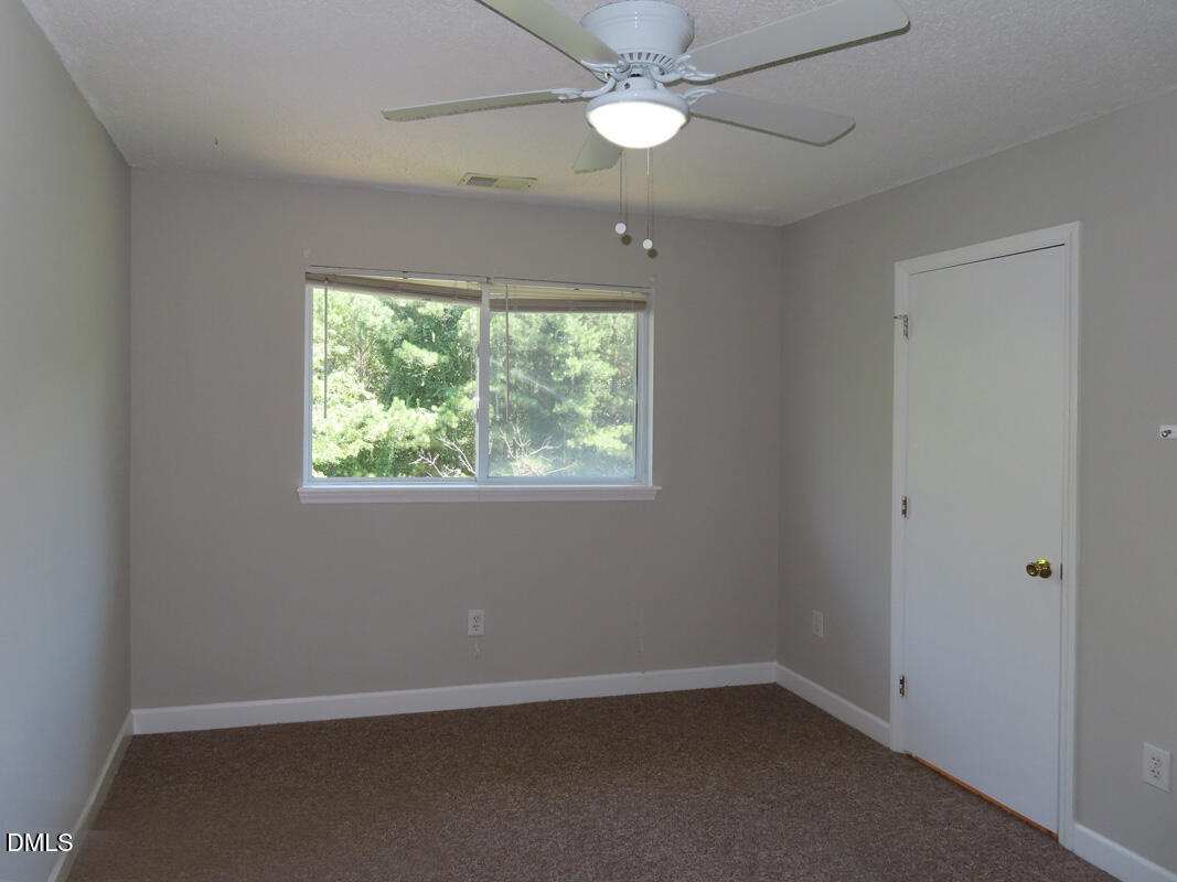 303 Smith Level Road, Unit B31 Chapel Hill, NC 27516 - Photo 16 of 20 an empty room with a window and a fan