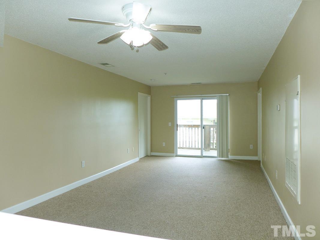 303 Smith Level Road, Unit B31 Chapel Hill, NC 27516 - Photo 6 of 20 an empty room with chandelier fan and windows