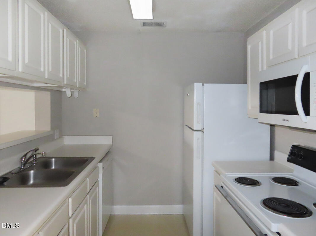 303 Smith Level Road, Unit B31 Chapel Hill, NC 27516 - Photo 8 of 20 a kitchen with stainless steel appliances granite countertop a sink stove and refrigerator
