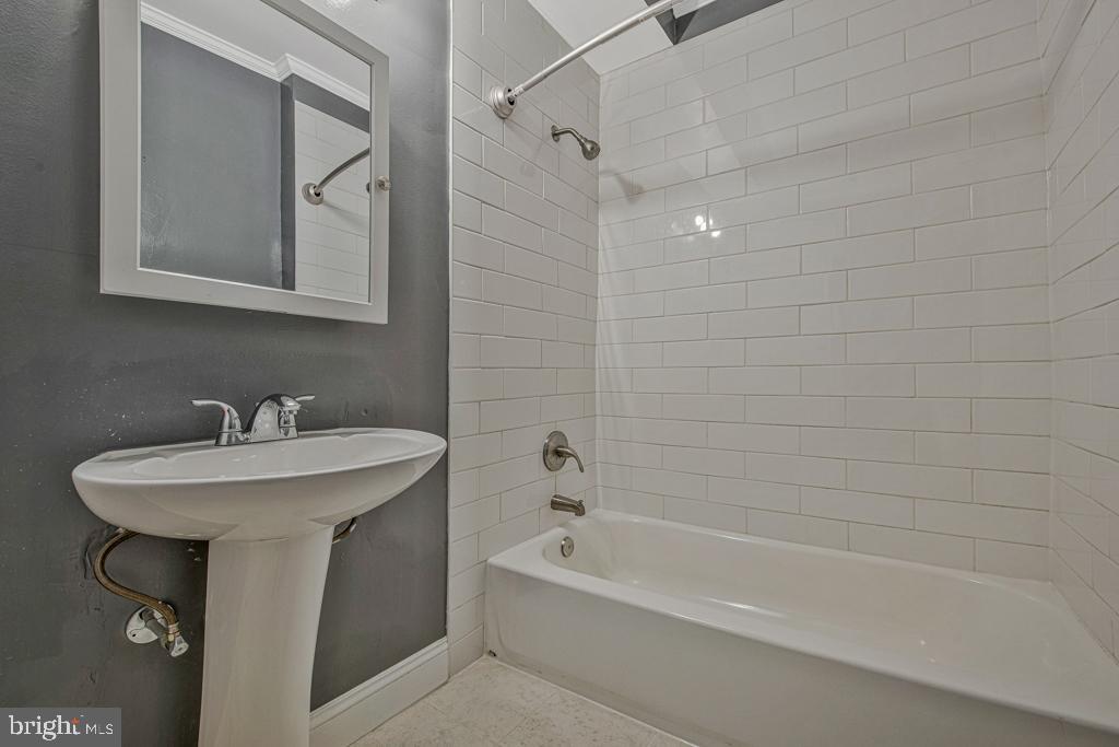2406 37th Street Northwest Washington, DC 20007 - Photo 33 of 44 a bathroom with a bathtub a sink a mirror and a shower