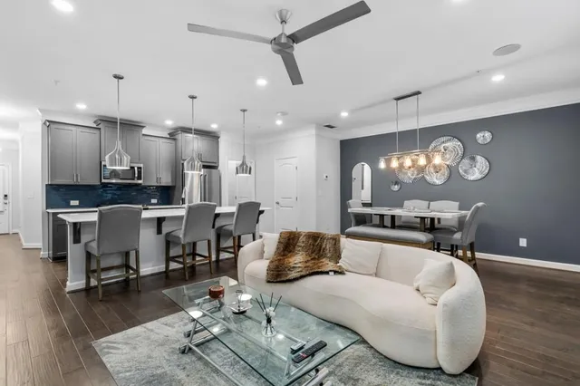 a living room with furniture kitchen view and a chandelier