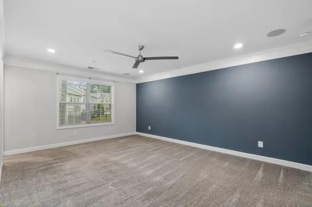 an empty room with windows and a ceiling fan