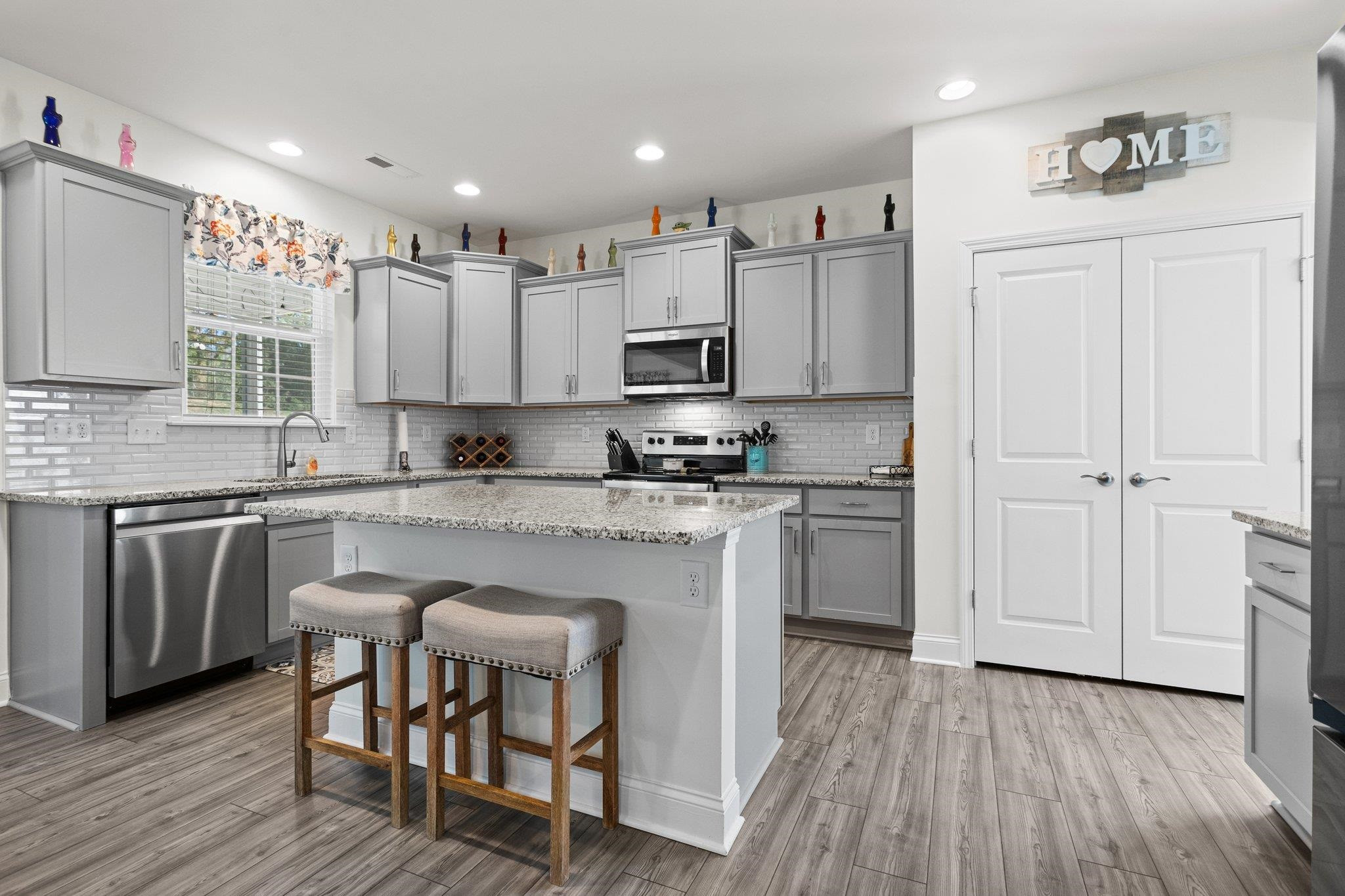 816 Heartpine Drive Mebane, NC 27302 - Photo 12 of 56 a kitchen with kitchen island granite countertop wooden floors white cabinets and appliances