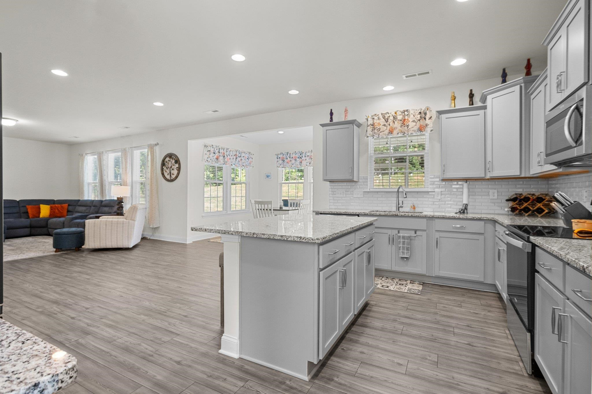 816 Heartpine Drive Mebane, NC 27302 - Photo 14 of 56 a large kitchen with stainless steel appliances granite countertop a lot of counter space and wooden floors