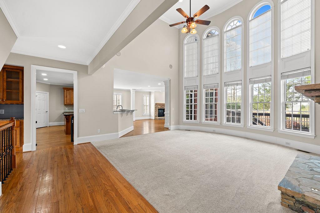 1037 Windermere Crossing Cumming, GA 30041 - Photo 11 of 95 a view of a livingroom with wooden floor a ceiling fan and windows