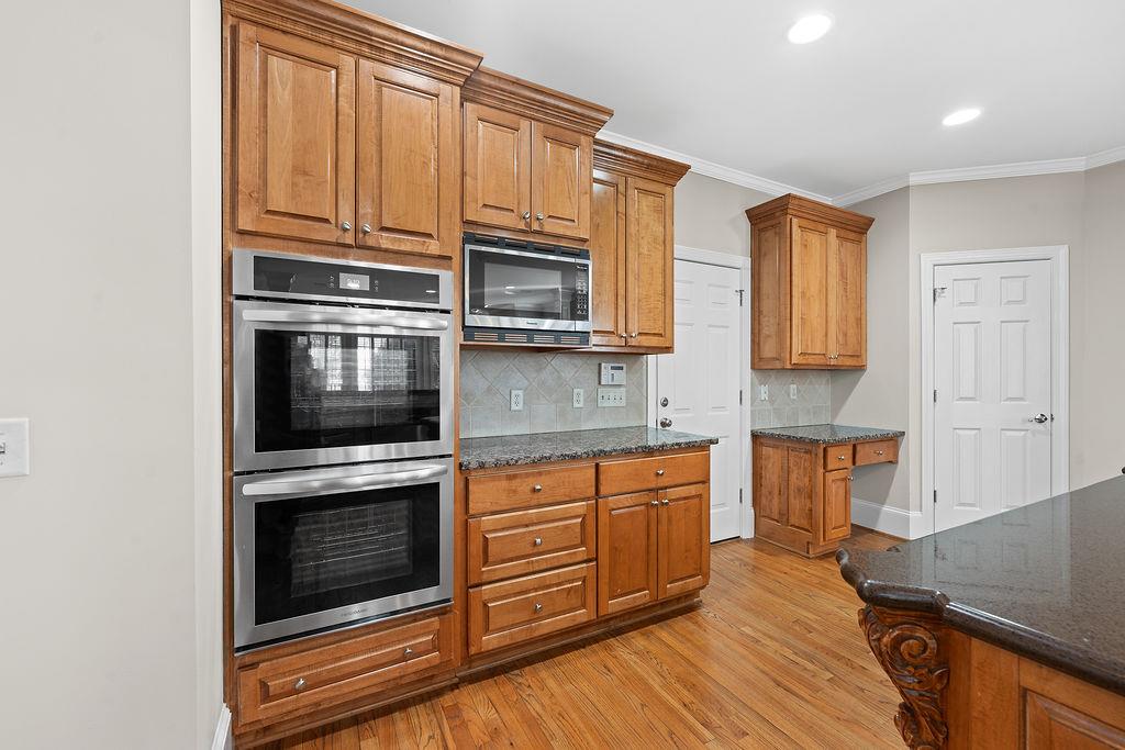 1037 Windermere Crossing Cumming, GA 30041 - Photo 22 of 95 a kitchen with stainless steel appliances granite countertop a stove microwave and cabinets