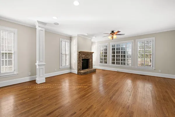 a view of staircase with lots of frames and frames on wall and wooden floor