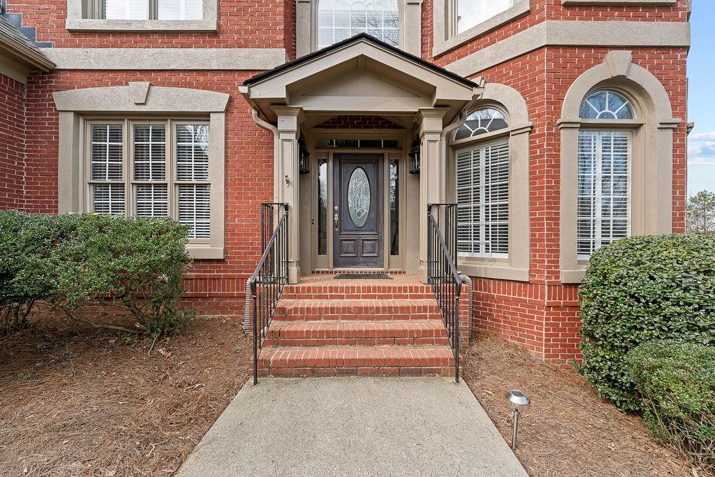 1037 Windermere Crossing Cumming, GA 30041 - Photo 4 of 95 a view of a house with large windows and a flower garden