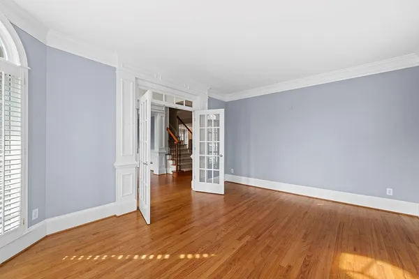 a view of an empty room with window and wooden floor