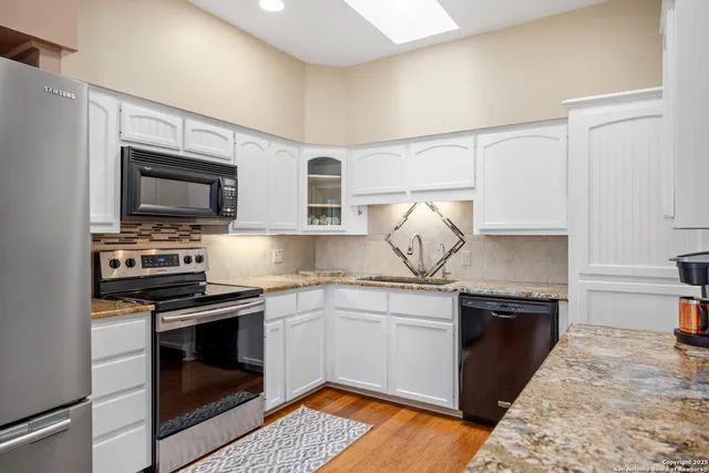 a kitchen with stainless steel appliances granite countertop a sink and stove top oven