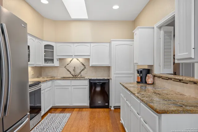 a kitchen with granite countertop a stove and cabinets