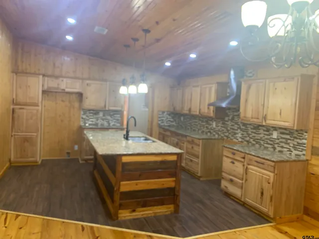 a kitchen with kitchen island a sink stainless steel appliances and cabinets